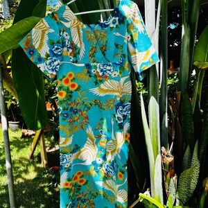 long blue dress with cutoff sleeves, floral patterns, and zipper in the back.